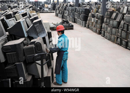 Un lavoratore cinese accumula scartato i televisori e altri dispositivi elettronici in corrispondenza di una stazione di riciclo di Chengdu, southwest Chinas nella provincia di Sichuan, 6 marzo 201 Foto Stock