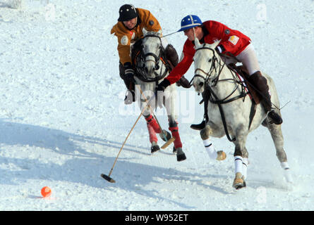 Un giocatore di Hong Kong (arancione) e un lettore di Inghilterra (rosso) competere in un match durante Asias prima neve Polo di Coppa del Mondo a Tianjin, Cina, 4 febbraio 2 Foto Stock