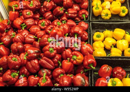 Peperoni rossi e gialli visualizzato in vassoi in un negozio di alimentari Foto Stock