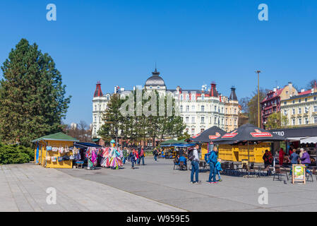 I turisti ed i visitatori godere giorno di sole in piazza di fronte Spa Hotel Thermal, surround con outdoor mercati temporanei con tantissime bancarelle e bistro. Foto Stock