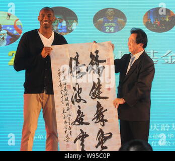 NBA superstar Kobe Byrant, sinistra, riceve un'opera calligrafica come regalo da un ospite durante un banchetto di beneficenza di Kobe Bryant Fondo di Cina a Shanghai, Foto Stock