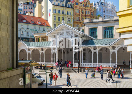 Outdoor sunny view di turisti a piedi sul lungomare davanti al colonnato del mercato, stile svizzero in legno intagliato colonnade arbour pavilion. Foto Stock