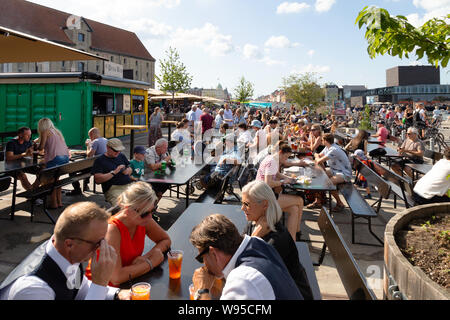 Persone mangiare fuori a Copenhagen street market alimentare in estate, Grønlandske Handels Plads, Copenhagen, Danimarca Scandinavia Europa Foto Stock
