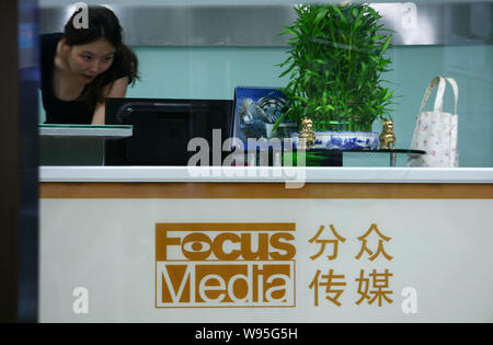 --FILE--un dipendente cinese lavora alla reception presso la sede di Focus Media in Cina a Shanghai, 15 agosto 2012. Focus Media Holding Ltd., Foto Stock