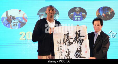 NBA superstar Kobe Byrant, sinistra, riceve un'opera calligrafica come regalo da un ospite durante un banchetto di beneficenza di Kobe Bryant Fondo di Cina a Shanghai, Foto Stock
