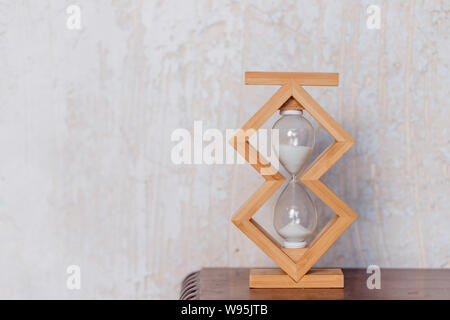 Close up di clessidra orologio su un pavimento di legno con copia spazio. Tempo di clessidra passando per il concetto di business scadenza, urgenza e in esecuzione fuori del tempo Foto Stock