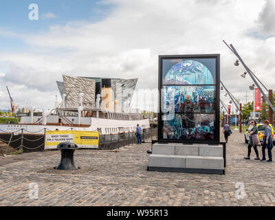 Il vetro macchiato installazione celebrando gioco di troni in Titanic Quarter, Belfast. SS nomade e Titanic Belfast sono in background Foto Stock