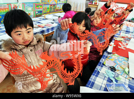 Studenti Cinesi mostrano la carta-cut opere del drago hanno effettuato a una scuola primaria nella città Taizi, Zouping county, Binzhou city east Chinas Shandong pr Foto Stock