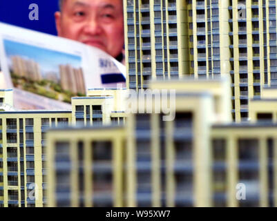 --FILE--un homebuyer guarda al modello di edifici di appartamento residenziale progetto durante una fiera immobiliare in Cina a Shanghai, 18 marzo 2011. Nuova home page Foto Stock