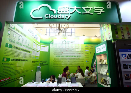 --FILE--dipendenti cinesi parla con i visitatori allo stand di Cloudary, in precedenza chiamato Shanda letteratura (SDL), durante la Shanghai Fiera del libro di Shang Foto Stock