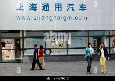 --File--pedoni a piedi passato un cartellone di Shanghai GM in Cina a Shanghai, 12 maggio 2010. Chinas centrale provincia di Hubei ha rivelato che il fabbricante automobilistico Foto Stock