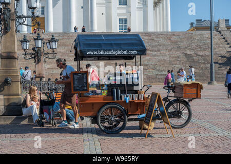 Helsinki, Finlandia -- Luglio 19, 2019. Un fornitore ha un carrello prodotti alimentari istituito dalle scale presso Tuomiokirkko, il 'Grande chiesa bianca". Foto Stock