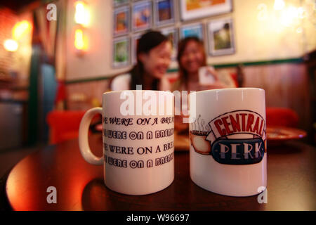 Giovani donne godono di torte e caffè in un Central Perk cafe a Shanghai in Cina, 3 settembre 2012. Central Perk, un punto morto sulla copia del cafe dal televisore Foto Stock