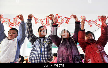 Studenti Cinesi mostrano la carta-cut opere del drago hanno effettuato a una scuola primaria nella città Taizi, Zouping county, Binzhou city east Chinas Shandong pr Foto Stock