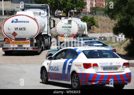 Lisbona, Portogallo. 12 Ago, 2019. Scorta di polizia di combustibile-petroliere lasciando il Humberto Delgado Aeroporto di Lisbona, in Portogallo, il 12 agosto, 2019. Carburante portoghese-cisterna drivers' sciopero nazionale ha cominciato come programmato da lunedì per un periodo indeterminato. In Portogallo il governo ha ordinato i servizi minimi di tra 50% e 100% e ha dichiarato una crisi energetica che implica "misure eccezionali' per ridurre al minimo gli effetti di sciopero per garantire la fornitura di servizi essenziali come le forze di sicurezza e le emergenze mediche. Credito: Pedro Fiuza/Xinhua Foto Stock