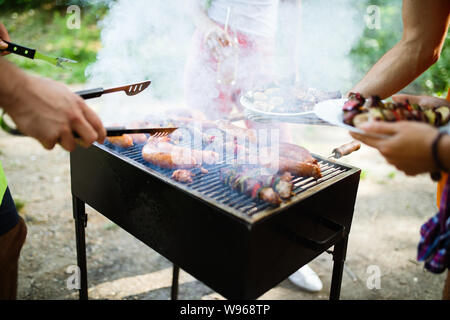 Happy amici godendo di barbecue e grigliata all'aperto Foto Stock