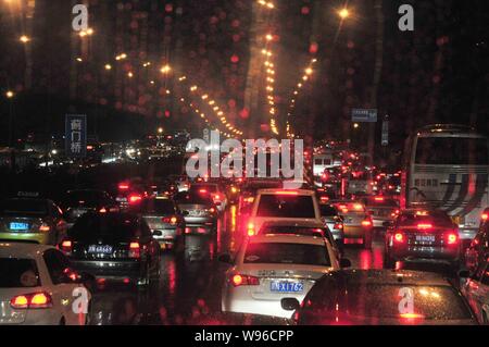 I veicoli si muovono lentamente sotto la pioggia su una strada nel traffico durante le ore di punta a Pechino in Cina, 25 settembre 2012. Gli inceppamenti di traffico potrebbe seriamente Foto Stock