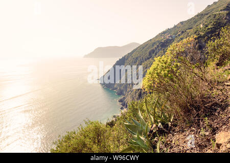 Cinque Terre, Italia - soleggiato viaggio romantico site con coste scoscese e ripide scogliere su mare e piccoli villaggi fino sulle colline al tramonto. Famoso turiste Foto Stock