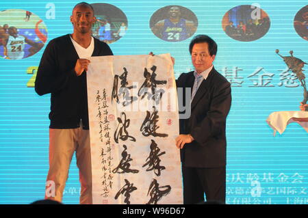 NBA superstar Kobe Byrant, sinistra, riceve un'opera calligrafica come regalo da un ospite durante un banchetto di beneficenza di Kobe Bryant Fondo di Cina a Shanghai, Foto Stock