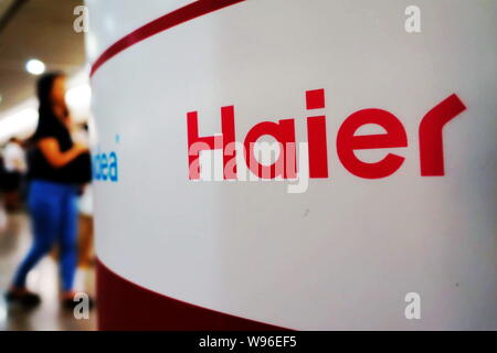 --FILE--pedoni a piedi passato la segnaletica di Haier in Cina a Shanghai, 8 giugno 2012. Porcellane più grande home appliance maker, Haier Group, ha dichiarato bo Foto Stock