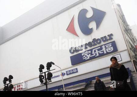 --File--pedoni camminare davanti a un supermercato Carrefour di Tianjin, Cina, 17 marzo 2012. Etichetta errata dei prezzi dei generi alimentari a Carrefour Hanfu supermercati in W Foto Stock