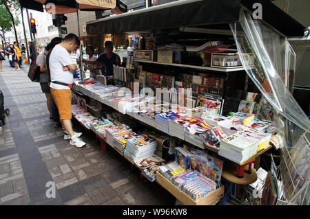 Persone comprare riviste in Edicola a Hong Kong, Cina, 28 giugno 2012. Chinas Consiglio di Stato, o l'armadio, annunciato a fine giugno misure volte a Foto Stock