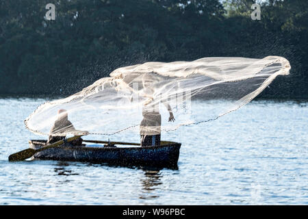 I pescatori usano un cast net presso il lago in Catemaco Catemaco, Veracruz, Messico. La tropicale lago di acqua dolce al centro della Sierra de Los Tuxtlas, è una destinazione turistica popolare e conosciuto per libera compresa scimmie, la foresta pluviale sfondo e streghe messicano noto come Brujos. Foto Stock