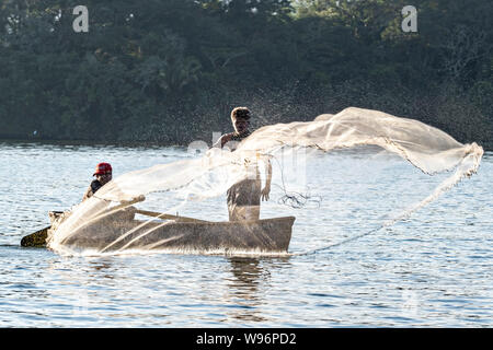 I pescatori usano un cast net presso il lago in Catemaco Catemaco, Veracruz, Messico. La tropicale lago di acqua dolce al centro della Sierra de Los Tuxtlas, è una destinazione turistica popolare e conosciuto per libera compresa scimmie, la foresta pluviale sfondo e streghe messicano noto come Brujos. Foto Stock