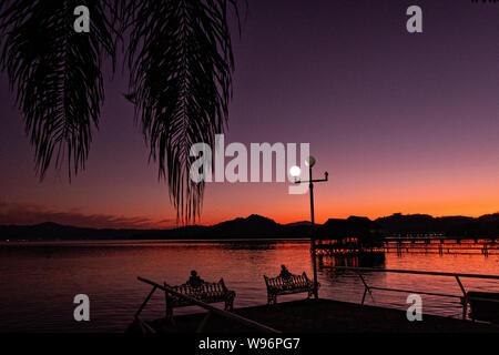 Tramonto sul lago in Catemaco Catemaco, Veracruz, Messico. La tropicale lago di acqua dolce al centro della Sierra de Los Tuxtlas, è una destinazione turistica popolare e conosciuto per libera compresa scimmie, la foresta pluviale sfondo e streghe messicano noto come Brujos. Foto Stock