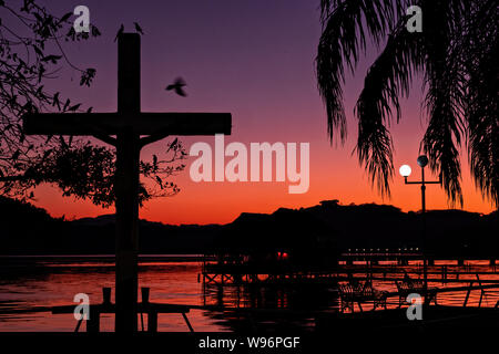 Tramonto sul lago in Catemaco Catemaco, Veracruz, Messico. La tropicale lago di acqua dolce al centro della Sierra de Los Tuxtlas, è una destinazione turistica popolare e conosciuto per libera compresa scimmie, la foresta pluviale sfondo e streghe messicano noto come Brujos. Foto Stock