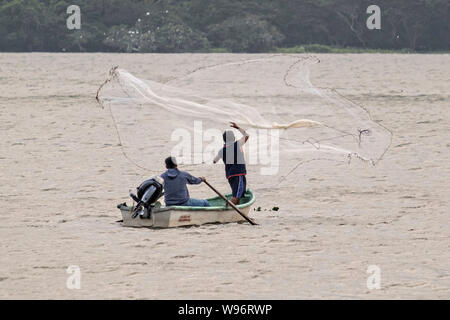 I pescatori usano un cast net presso il lago in Catemaco Catemaco, Veracruz, Messico. La tropicale lago di acqua dolce al centro della Sierra de Los Tuxtlas, è una destinazione turistica popolare e conosciuto per libera compresa scimmie, la foresta pluviale sfondo e streghe messicano noto come Brujos. Foto Stock