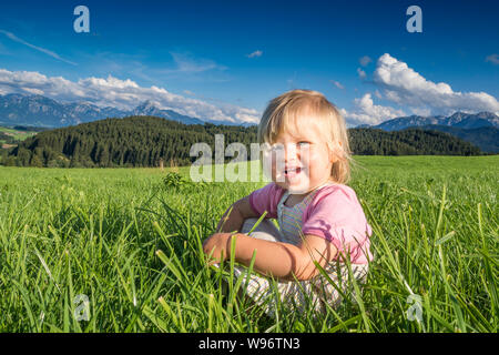 In Germania, in Baviera, Allgaeu, Happy Baby girl giocando nei campi Foto Stock
