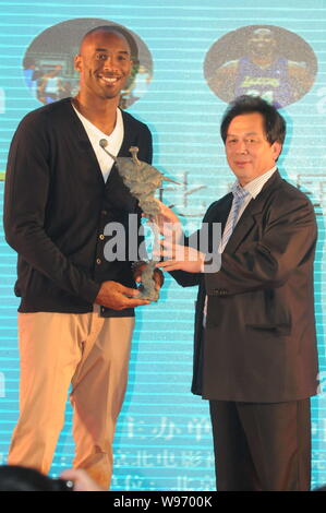 NBA superstar Kobe Byrant, sinistra, riceve un regalo da un ospite durante un banchetto di beneficenza di Kobe Bryant Fondo di Cina a Shanghai in Cina, 14 agosto 201 Foto Stock