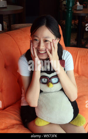 Una giovane donna reagisce sul lettino arancione in una centrale di Perk cafe a Shanghai in Cina, 3 settembre 2012. Central Perk, un punto morto sulla copia del cafe da Foto Stock