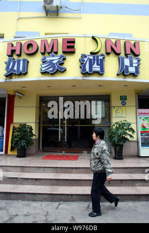 --FILE--A passeggiate a piedi passato una Casa Inn hotel in Cina a Shanghai, 11 aprile 2012. Home Inns & Hotels Management Inc., porcellane più grande budget hotel Foto Stock