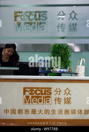 --FILE--un dipendente cinese lavora alla reception presso la sede di Focus Media in Cina a Shanghai, 15 agosto 2012. Shanghai-base outdoor adv Foto Stock