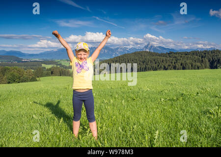 In Germania, in Baviera, Allgaeu, felice ragazza tifo nei campi Foto Stock