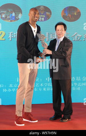 NBA superstar Kobe Byrant, sinistra, riceve un regalo da un ospite durante un banchetto di beneficenza di Kobe Bryant Fondo di Cina a Shanghai in Cina, 14 agosto 201 Foto Stock