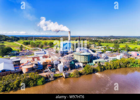 Lo zucchero allo stabilimento di trasformazione dello zucchero - mulino sulle rive del fiume pigro in Australian pianure tropicali della canna da zucchero agricoli le aziende agricole e i campi. Grande ciminiera sen Foto Stock