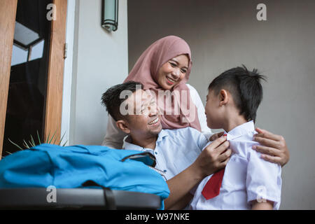 Indonesia famiglia con bambini che indossano uniformi scolastiche Foto Stock