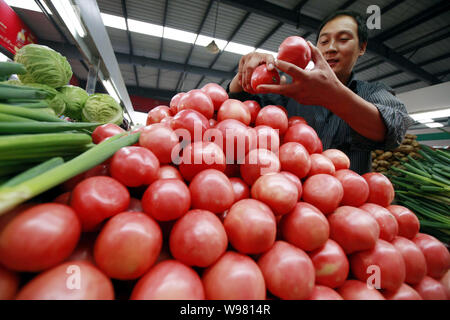 Un fornitore cinese vende pomodori e altri ortaggi in un libero mercato in città Huaibei, est Chinas provincia di Anhui, 9 settembre 2011. Chinas consumer Foto Stock