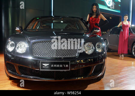 --FILE -- un modello pone accanto a una Bentley Continental Flying Spur durante un auto show di Hangzhou, est Chinas nella provincia di Zhejiang, 13 ottobre 2010. Foto Stock