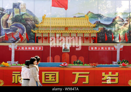 Locali residenti cinesi a piedi passato una replica del rostro di Tiananmen essendo visualizzato per celebrare il prossimo Festival di Primavera, noto anche come il mento Foto Stock