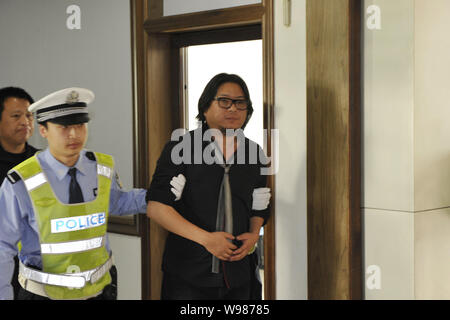 Musicista cinese e porcellane Got Talent giudice Gao Xiaosong, destra, passeggiate fuori da un inchiesta camera con un poliziotto dal suo lato in corrispondenza di una stazione di polizia in B Foto Stock