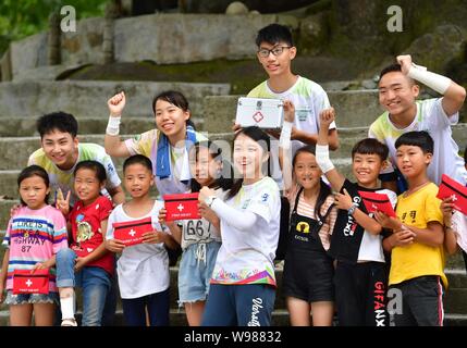 (190812) -- RONGSHUI, Agosto 12, 2019 (Xinhua) -- volontari provenienti da Macao e bambini locali gesto durante una classe di salute a Wuying, un villaggio di Miao gruppo etnico sotto amministrazione congiunta da Rongshui County in Guangxi Zhuang Regione autonoma e la sua Congjiang vicina contea di Guizhou, sud-ovest della Cina, il 10 agosto 2019. Più di trenta studenti volontari provenienti dal sud della Cina di Macao ha offerto un corso di una settimana il servizio di insegnamento per bambini in questo remoto villaggio. Volontari disposti a varie classi di pittura, deliberando, scienza e PE per arricchire bambini locali di vacanze estive e ampliare t Foto Stock