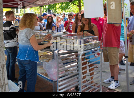 Mercato degli Agricoltori, Madison, WI, Stati Uniti d'America. Aug 2018. La donna il cliente paga per il suo ordine di beni cotti al forno. Foto Stock