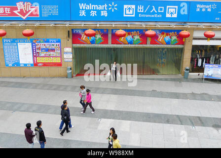 --FILE--i residenti locali a piedi passato un Walmart Supercenter a Chongqing Cina, 29 settembre 2011. Il governo del sud-ovest Chinas Municip di Chongqing Foto Stock