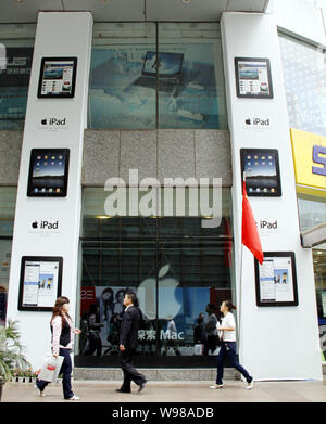 --FILE--Cinesi locali residenti a piedi passato pubblicità per iPad tablet PC al di fuori di un Apple store nella città di Nanjing East Chinas provincia dello Jiangsu, 7 Foto Stock