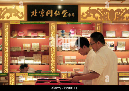 --FILE--dipendenti cinesi preparare la medicina di erbe in un TongRenTang TCM (medicina tradizionale cinese) farmacia in Cina a Shanghai, 14 luglio 2011. Tra Foto Stock