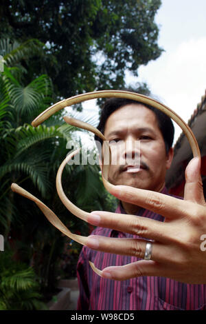 Un uomo cinese soprannominato Feng mostra fuori le sue unghie lunghe nel centro della città di Haikou, sud Chinas Hainan Provincia, 13 marzo 2011. Feng ha detto ai giornalisti che egli Foto Stock
